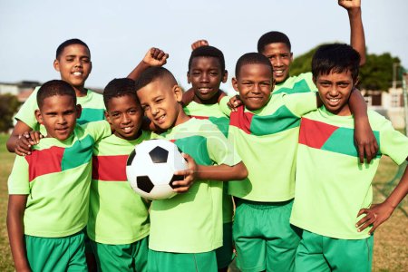 Foto de Sueño, creer, lograr. Retrato de un equipo de fútbol masculino de pie juntos en un campo de deportes - Imagen libre de derechos