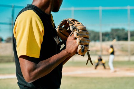 Téléchargez les photos : Ce lancer le fera ou le brisera. un jeune joueur de baseball se préparant à lancer la balle pendant un match en plein air - en image libre de droit