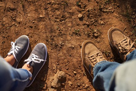 Téléchargez les photos : Mets de la saleté sur tes chaussures. Coupé plan grand angle de deux personnes debout sur une piste de terre - en image libre de droit
