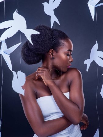 Photo for You wont know beauty into you discover freedom. Studio shot of a beautiful young woman posing with paper birds against a black background - Royalty Free Image