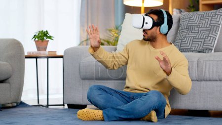 Photo for Home, virtual reality glasses and man on the floor, metaverse and online game with fun in a living room. Person, futuristic or player with esports, tech or VR eyewear with headphones or stress relief. - Royalty Free Image