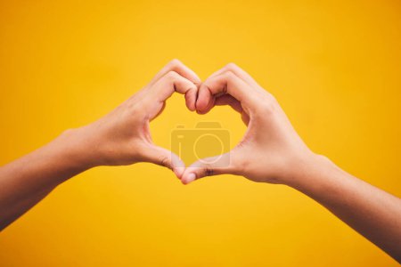 Téléchargez les photos : Coeur, mains et personne en studio avec remerciements, message ou geste sur fond orange. Emoji, cadre et doigts humains avec amour-propre, gratitude et gentillesse, empathie et espoir de guérison. - en image libre de droit