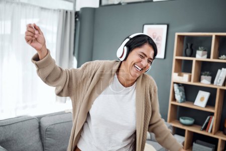 Photo for Senior, dance or happy woman streaming music or laughing to relax with freedom in home living room. Retirement, headphones or excited senior person listening to radio song or audio with joy or smile. - Royalty Free Image