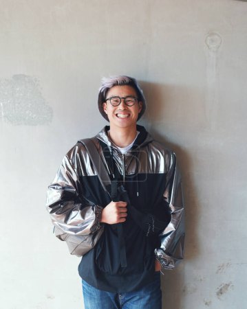 Photo for Portrait, fashion and Asian man with a smile, streetwear and stylish outfit against a wall background. Male person, happy model and student with glasses, trendy clothes and happiness with confidence. - Royalty Free Image