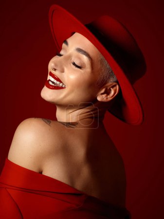 Photo for Fashion, funny and a model woman on a red studio background for elegant or trendy style. Aesthetic, art and beauty with a young female person laughing in an edgy or classy unique clothes outfit. - Royalty Free Image