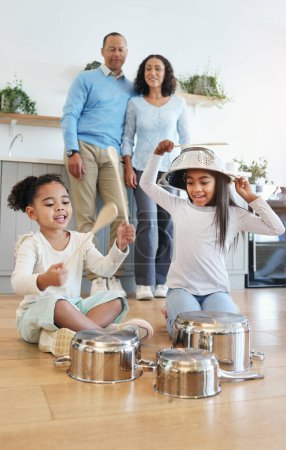 Photo for Funny, playing and children with pots for drums with parents watching with love in their home kitchen. Family, happy and crazy playful siblings making noise on metal to play a sound for mom and dad. - Royalty Free Image
