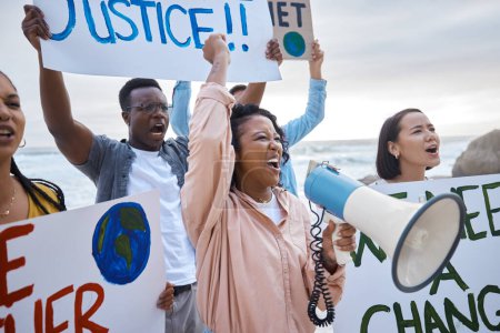 Foto de Cartel de cambio climático, megáfono y protesta de mujeres con multitud en la playa protestando por el medio ambiente y el calentamiento global. Salvemos la tierra, el activismo grupal y la gente gritando al megáfono para detener la contaminación - Imagen libre de derechos