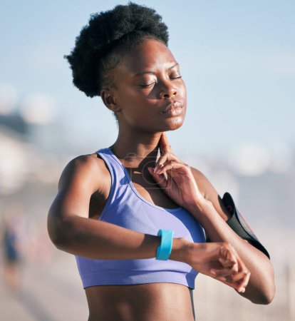 Photo for Fitness, wellness and athlete checking her pulse with smartwatch for running outdoor in nature. Sports, workout and African woman monitoring her heart rate for cardio training for race or marathon - Royalty Free Image