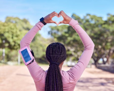 Photo for Fitness, heart hands and black woman with phone monitor for running, cardio and workout progress, health and data. Sports person rear or athlete runner with love emoji and smartphone for training. - Royalty Free Image