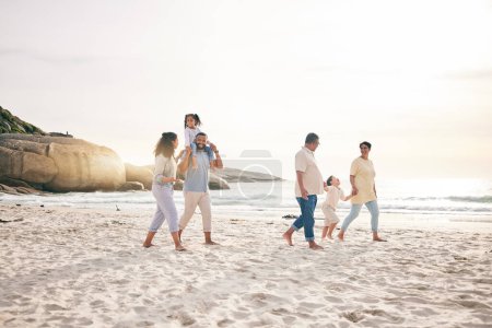 Photo for Holding hands, walking and big family at a beach for travel, vacation and fun in nature together. Freedom, parents and children relax with grandparents at the sea at sunset, trip or ocean holiday. - Royalty Free Image
