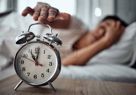Photo for Alarm, morning and a hand with a clock for awake, oversleep or tired in the bedroom of a home. House, ring and a closeup of a person or woman in bed for snooze, rest or waking up lazy in a house. - Royalty Free Image