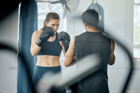 Photo for Boxing fitness training with coach at gym, angry woman learning self defense with trainer and learning cardio exercise for wellness at sports club. Male instructor teaching workout class at center. - Royalty Free Image
