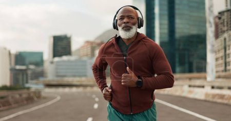 Téléchargez les photos : Mature, personne et courir en ville avec des écouteurs pour la forme physique, l'entraînement et la musique d'entraînement de marathon. Podcast d'homme, d'athlète ou d'exercice noir en Afrique du Sud pour la radio cardio-bien-être, santé ou sport. - en image libre de droit