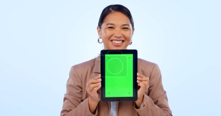 Foto de Retrato, tableta y espacio de pantalla verde con una mujer asiática en el estudio sobre un fondo azul para la promoción del sitio web. Tecnología, maqueta o cromakey y una persona que sostiene una pantalla con marcadores de seguimiento. - Imagen libre de derechos