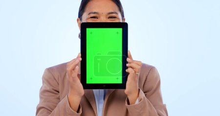 Photo for Portrait, tablet and green screen mockup with an asian woman in studio on a blue background for website promotion. Tech, space or chromakey and a person holding a display with tracking markers. - Royalty Free Image