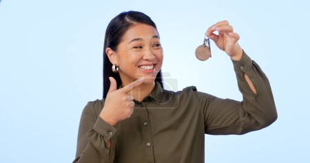 Photo for Smile, woman and pointing at keys for real estate, new home and property in studio isolated on a blue background mockup space. Happy person with keychain for house mortgage, apartment rent and moving. - Royalty Free Image