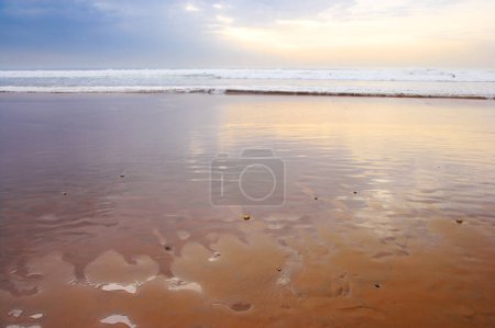 Téléchargez les photos : Paysage marin et paysage d'un coucher de soleil doré sur la côte ouest du Jutland à Loekken, Danemark. Beau paysage nuageux sur une plage vide au crépuscule. Nuages sur l'océan et la mer dans la soirée avec copyspace. - en image libre de droit