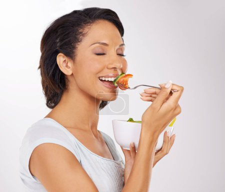 Photo for Happy woman, salad bowl and diet with fruit for natural nutrition against a studio background. Face of female person or model smile with organic food, fiber or vitamins for healthy meal and wellness. - Royalty Free Image