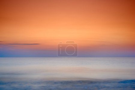 Téléchargez les photos : Paysage marin copyspace d'un coucher de soleil orange sur la côte ouest du Jutland à Loekken, Danemark. Coucher de soleil à l'horizon sur une plage vide au crépuscule sur l'océan et la mer la nuit. Lever du soleil le matin. - en image libre de droit