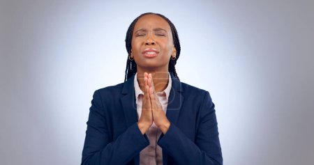 Téléchargez les photos : Femme priante, spirituelle et noire dans un studio pour la gratitude, le pardon et l'espérance compassion. Bénédiction, religion et jeune femme africaine avec geste de la main de prière isolé par fond gris - en image libre de droit