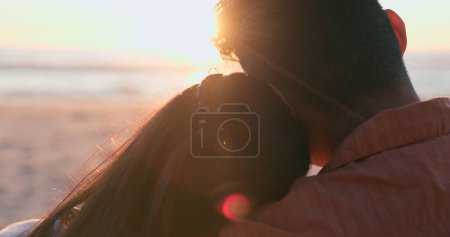 Photo for Sunset, beach and back of couple hug in nature for travel, bond or weekend freedom with lens flare. Sunrise, love and rear view or people embrace at sea for adventure, journey or romance at the ocean. - Royalty Free Image