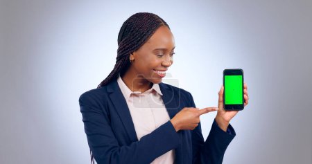 Photo for Business, woman and pointing to green screen of phone for advertising space, offer and mockup newsletter in studio. Happy african worker show mobile announcement, promotion or deal on grey background. - Royalty Free Image