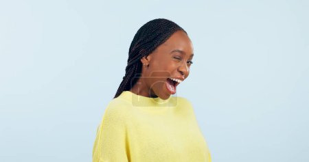 Foto de Guiño, coqueta y retrato de una mujer negra en un fondo de estudio para el amor, la conversación o una sonrisa. Espacio feliz, maqueta y una persona africana con expresión facial para un secreto o confianza. - Imagen libre de derechos
