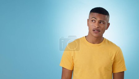 Photo for Thinking, confused or problem solving and a man on a blue background in studio with a question on mockup. Doubt, idea or why with a young person on space for planning or brainstorming a solution. - Royalty Free Image