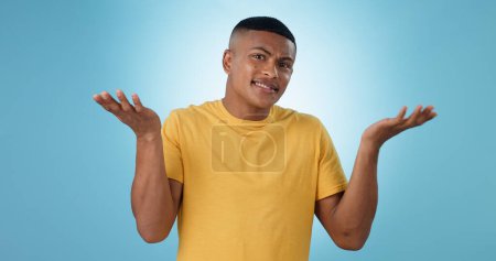 Photo for Confused, shrug and man portrait in studio with why hands on blue background space. Doubt, face and model with dont know emoji for choice, decision or palm scale, questions or asking body language. - Royalty Free Image
