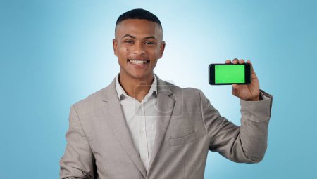 Photo for Business man, phone green screen and portrait for presentation, advertising information or trading software in studio. Happy, face and young trader on mobile app, tracking markers and blue background. - Royalty Free Image