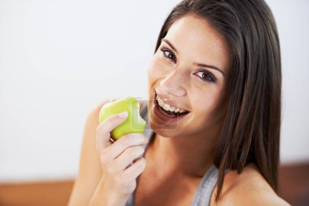 Photo for Woman, smile and eating an apple, health and wellness in portrait, nutrition and vitamins for vegan. Female person, fruit and organic or natural, breakfast and diet in outdoors, fresh and digestion. - Royalty Free Image