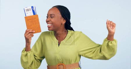 Photo for African woman, passport and studio with fist celebration for airplane ticket, document or excited by blue background. Girl, legal paperwork and win for compliance, immigration or international travel. - Royalty Free Image