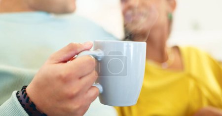 Photo for Coffee cup, closeup and couple on couch for drink, conversation and relax together in home living room. Man, woman and zoom of tea, coco or espresso in lounge, sofa and talking with bonding in house - Royalty Free Image