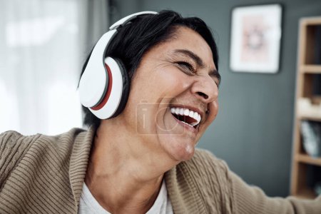 Photo for Headphones, face or happy woman streaming music or dancing to relax with freedom at home. Retirement, smile or excited senior person laughing or listening to a radio song or audio on subscription. - Royalty Free Image