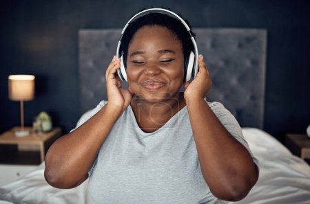 Photo for Crying, smile and black woman with headphones for music, sound or audio. Tears, radio and plus size African person listening, hearing and streaming podcast for peace or relax in home bedroom at night. - Royalty Free Image
