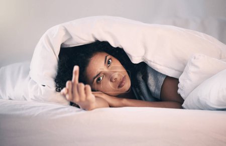 Photo for Angry, woman with insomnia and portrait in bed with a middle finger for morning or waking up, sleeping in bedroom or at home. Hand, show a curse sign and frustrated with sleep problem at night. - Royalty Free Image