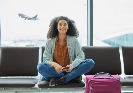 Photo for Airport, black woman and portrait of a young person at flight terminal waiting for airplane travel. Passport document, smile and sitting solo female traveler feeling happy with freedom from adventure. - Royalty Free Image