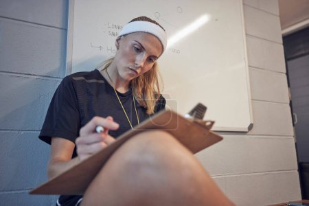 Photo for Sports, thinking and coach planning a strategy for fitness training, workout and exercise on a clipboard. Leadership, woman and personal trainer writing a coaching schedule with goals tactics at gym. - Royalty Free Image