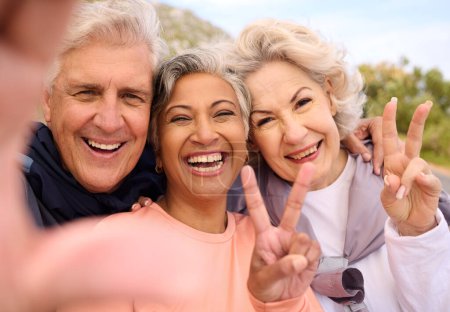 Photo for Senior friends, fitness and selfie outdoor with peace sign, portrait and diversity on social media. Happy old man, women and photography for memory, emoji or profile picture for workout in retirement. - Royalty Free Image