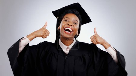 Photo for Graduation, woman and student thumbs up for study success, celebration and education, learning or college in studio. Portrait of excited African graduate with yes and like emoji on a white background. - Royalty Free Image