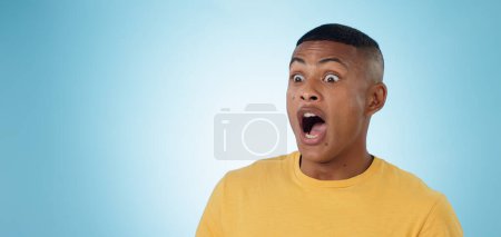 Photo for Wow, surprise and shocked man in studio with news, information or promotion on blue background. Omg, emoji and face of male model with unexpected announcement, gossip or confused by secret giveaway. - Royalty Free Image