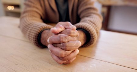 Photo for Hands together, person and stress with table and problem from despair and praying. Anxiety, hope and issue in a retirement home with grief, religion and challenge at a house with worry or gratitude. - Royalty Free Image