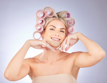 Photo for Hair care, rollers and portrait of woman in a studio doing a natural, beautiful and curly hairstyle. Self care, happy and attractive female model with curlers for beauty isolated by a gray background. - Royalty Free Image