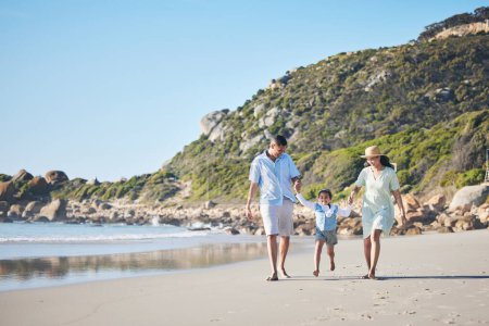 Photo for Beach, mother and father holding hands with a child for fun, family adventure and play on holiday. A happy woman, man and young kid walking on sand for vacation at ocean, nature or outdoor in summer. - Royalty Free Image