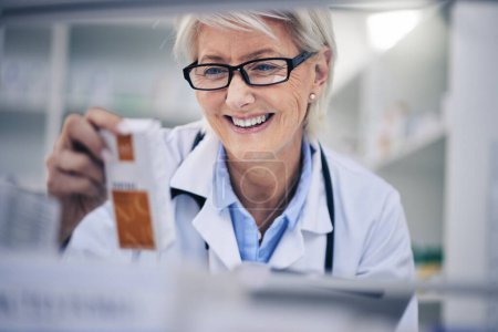 Photo for Happy woman, pharmacist and reading medication on shelf for inventory, diagnosis or prescription at pharmacy. Mature female person, medical or healthcare professional checking medicine in drugstore. - Royalty Free Image