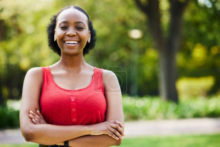 Téléchargez les photos : Portrait, bras croisés et heureuse femme noire dans le parc, en plein air et le jardin avec confiance, humeur drôle et la liberté au Nigeria. Visage, femme africaine et rire et sourire en été dans la nature. - en image libre de droit
