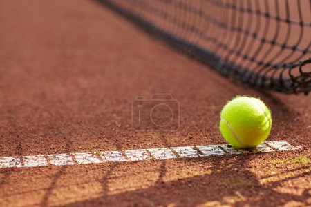 Photo for Tennis, ball and clay court, net and line for exercise, training and fitness outdoor in summer. Sports, netting and closeup of sphere on ground for game, competition and workout on field and pitch. - Royalty Free Image