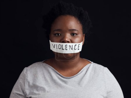 Téléchargez les photos : Portrait, censure et une femme noire en signe de protestation contre la violence domestique sur fond sombre. Liberté, égalité des sexes ou autonomisation avec une jeune femme sérieuse en studio pour les droits de l'homme. - en image libre de droit