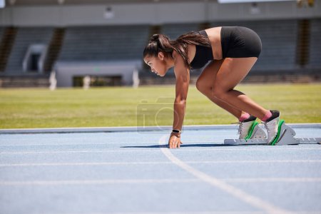 Photo for Running, sports and fitness with an asian woman athlete on a track for a race, marathon or endurance training. Health, workout and exercise with a female runner at the start of a competitive sport. - Royalty Free Image