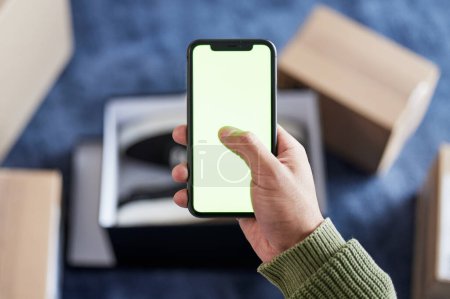 Photo for Phone green screen, boxes and person hands online shopping, scroll ecommerce site or check omnichannel website. Courier service, mail shipping or home customer with cellphone, delivery app or package. - Royalty Free Image